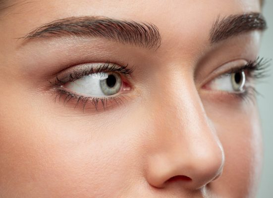 The beautiful female face. The perfect and clean skin of face on gray